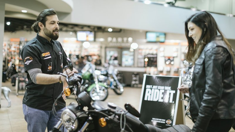 经销商员工帮助客户选购摩托车